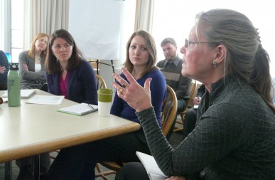 A woman speaks to a group about the Genuine Progress Idicator